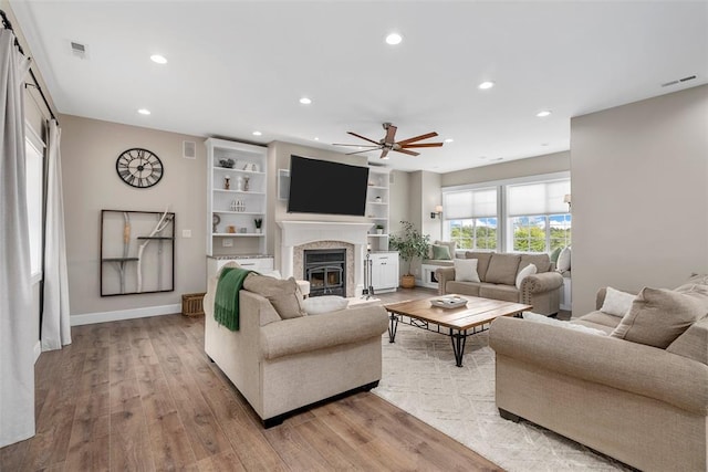 12930 Mohawk Dr, De Soto, MO 63020 - living room featuring ceiling fan, light wood finished floors, recessed lighting, a fireplace with flush hearth, and baseboards