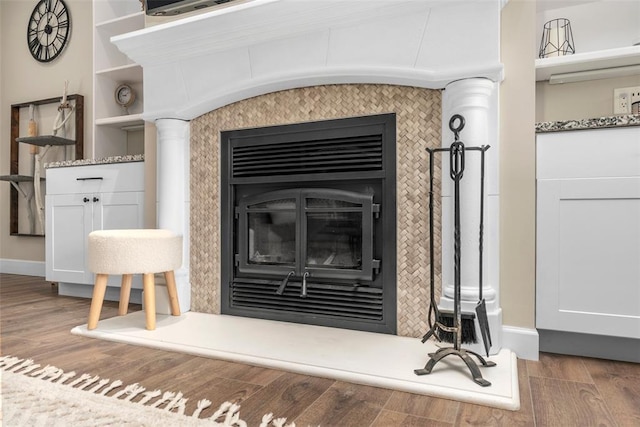 12930 Mohawk Dr, De Soto, MO 63020 - detailed view of a glass covered fireplace, wood finished floors, and baseboards
