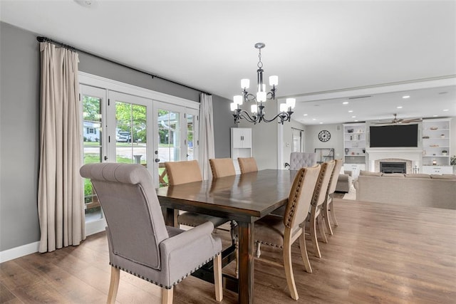 12930 Mohawk Dr, De Soto, MO 63020 - dining room featuring a fireplace, wood finished floors, french doors, a chandelier, and recessed lighting