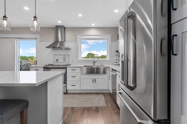 12930 Mohawk Dr, De Soto, MO 63020 - kitchen featuring stainless steel appliances, a sink, wall chimney exhaust hood, dark wood-style flooring, and tasteful backsplash