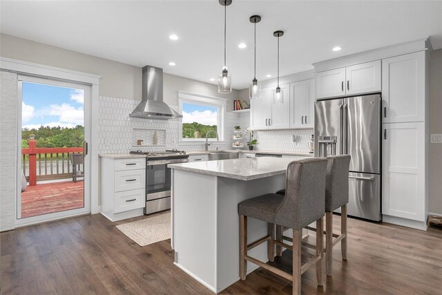12930 Mohawk Dr, De Soto, MO 63020 - kitchen with wall chimney range hood, appliances with stainless steel finishes, a sink, backsplash, and recessed lighting