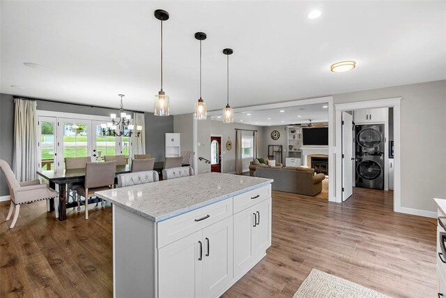 12930 Mohawk Dr, De Soto, MO 63020 - kitchen featuring stacked washer / dryer, healthy amount of natural light, a center island, a chandelier, and recessed lighting