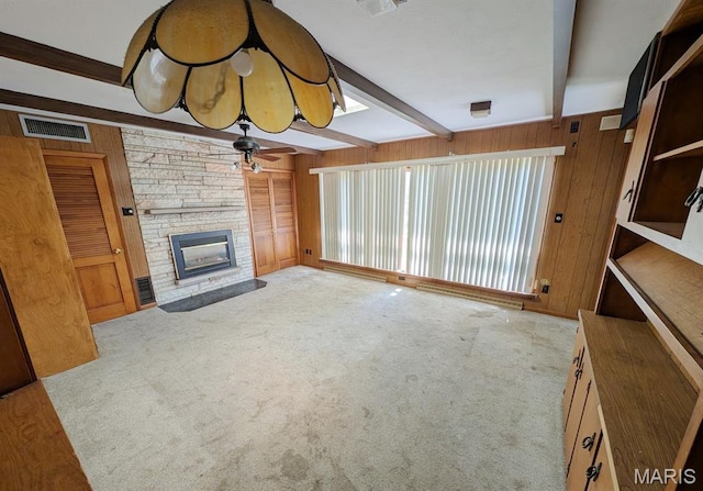 820 Lebanon Ave, Belleville, IL 62221 - unfurnished living room with beamed ceiling, wooden walls, a fireplace, carpet floors, and a ceiling fan
