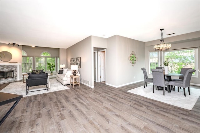 dining space featuring plenty of natural light, a chandelier, wood finished floors, and baseboards