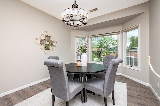 dining room featuring a chandelier, dark wood-type flooring, and baseboards