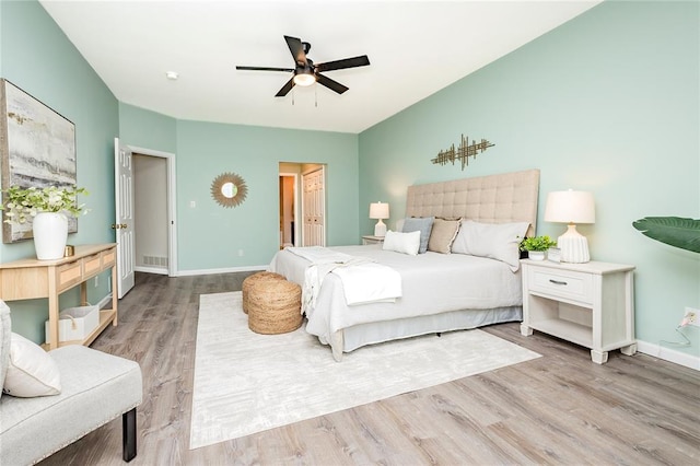 bedroom featuring wood finished floors, baseboards, and a ceiling fan