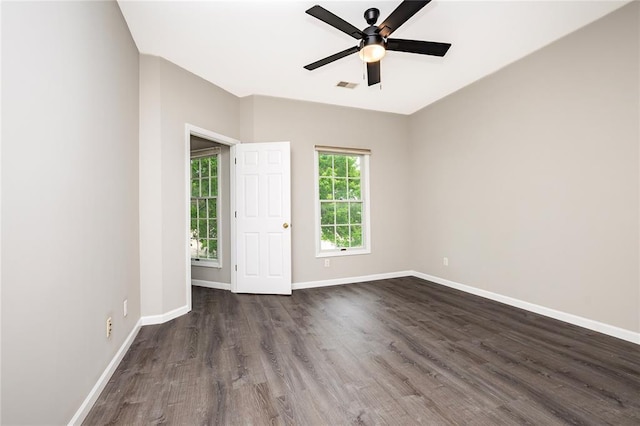 empty room with a ceiling fan, dark wood finished floors, and baseboards