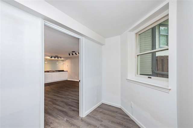 hallway featuring wood finished floors and baseboards