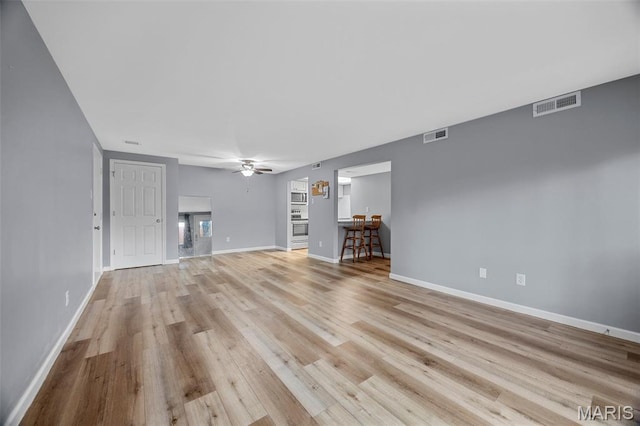 11 Fairways Cir Unit A, Saint Charles, MO 63303 - unfurnished living room with light wood finished floors, ceiling fan, and baseboards