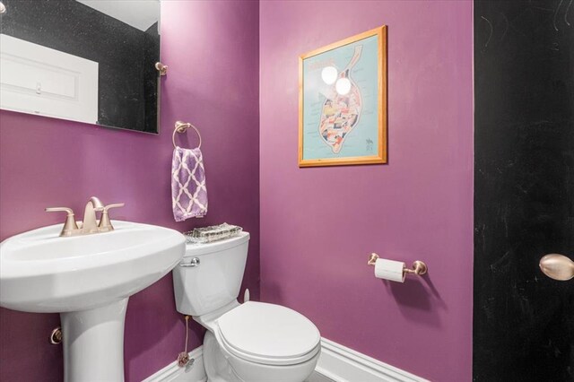 bathroom featuring toilet and baseboards