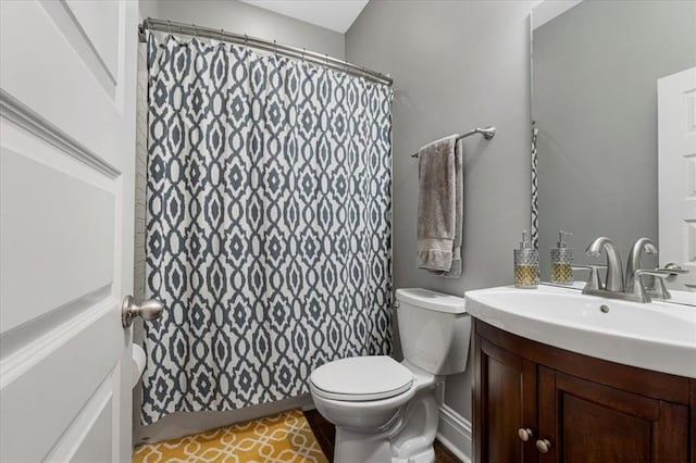 bathroom featuring toilet, vanity, and a shower with curtain