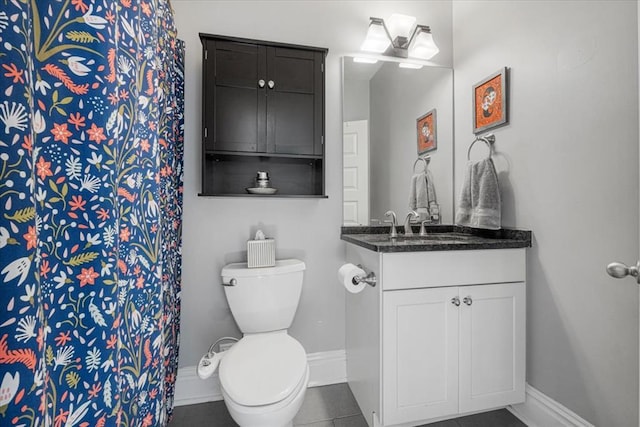 bathroom featuring baseboards, toilet, vanity, and tile patterned floors