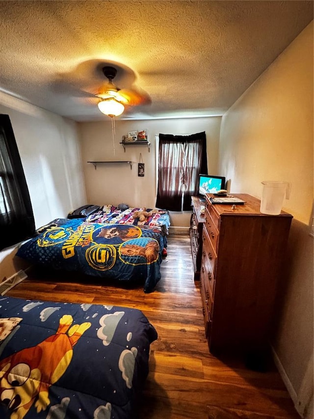 308 N Ellen St, Dixon, MO 65459 - bedroom with dark wood-style floors, a textured ceiling, and ceiling fan