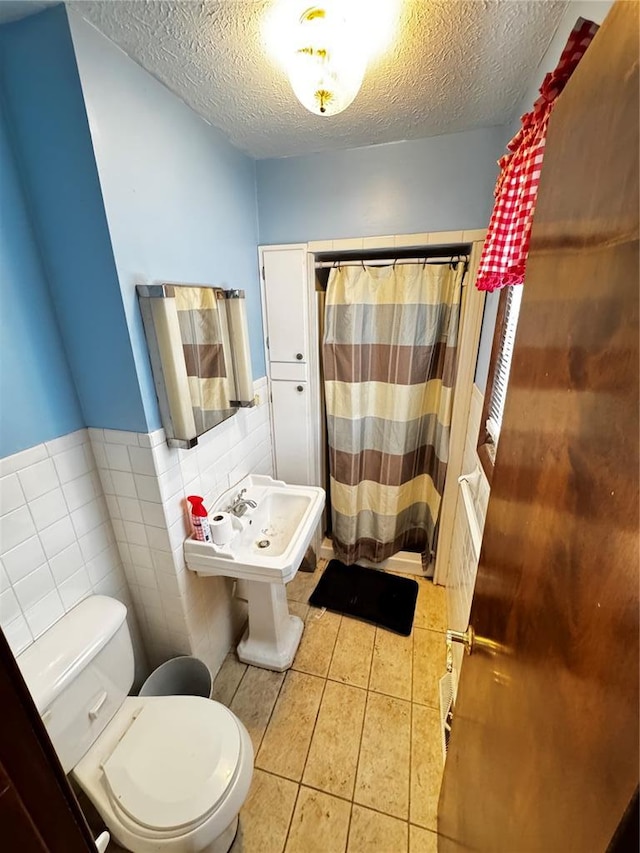 308 N Ellen St, Dixon, MO 65459 - bathroom featuring a textured ceiling, toilet, tile walls, tile patterned floors, and a shower with curtain