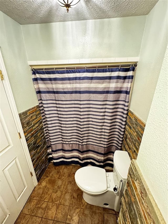 308 N Ellen St, Dixon, MO 65459 - full bath with toilet, a textured ceiling, a wainscoted wall, and a shower with shower curtain