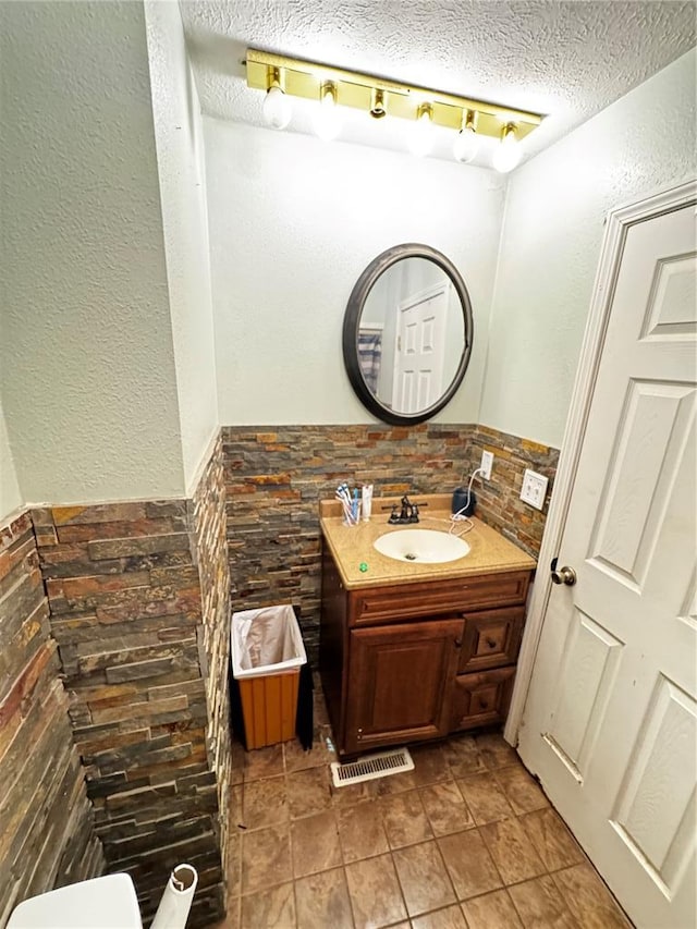308 N Ellen St, Dixon, MO 65459 - half bathroom with a textured ceiling, vanity, a textured wall, and wainscoting