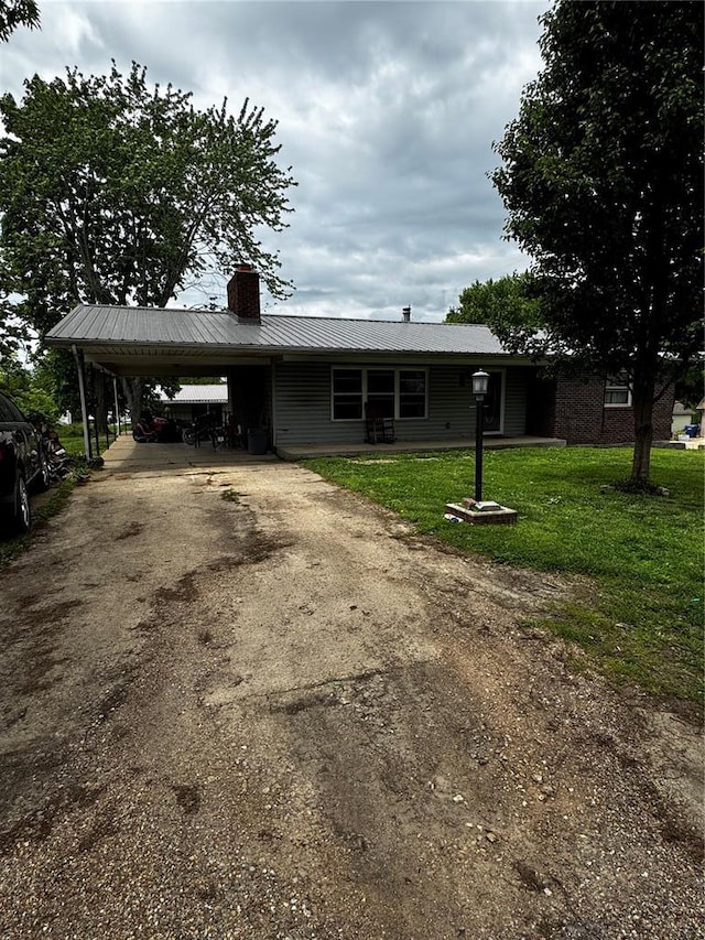 308 N Ellen St, Dixon, MO 65459 - ranch-style house with a chimney, asphalt driveway, a carport, a front lawn, and metal roof