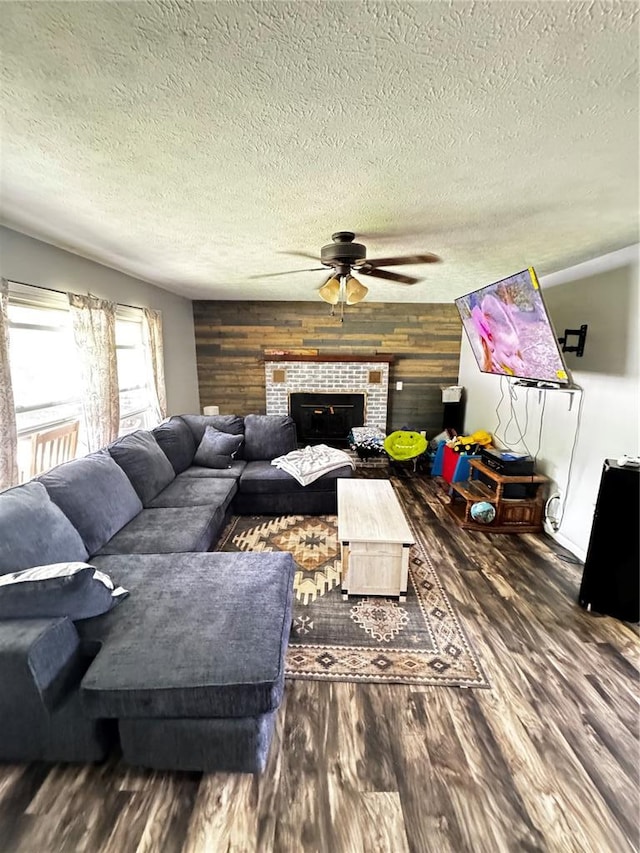 308 N Ellen St, Dixon, MO 65459 - living area with ceiling fan, wood finished floors, a textured ceiling, a tiled fireplace, and wood walls