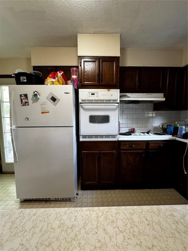 308 N Ellen St, Dixon, MO 65459 - kitchen featuring white appliances, under cabinet range hood, backsplash, dark brown cabinets, and light countertops