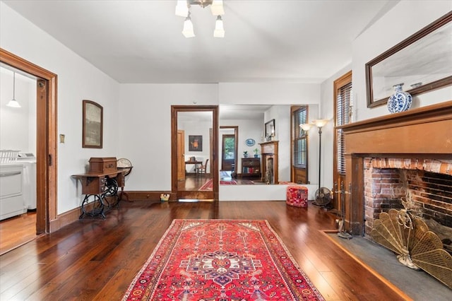 100 W Alton St, Marine, IL 62061 - living area with a brick fireplace, hardwood / wood-style flooring, baseboards, and washer and clothes dryer