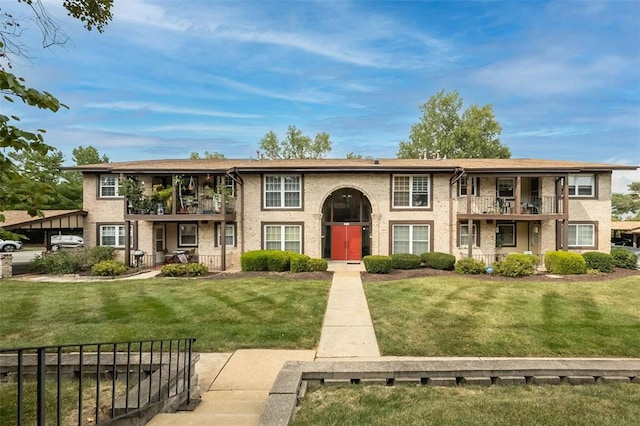 multi unit property featuring a balcony and a front lawn