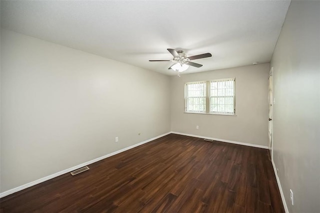 empty room with a ceiling fan, dark wood-type flooring, and baseboards