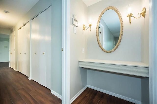 hallway featuring dark wood-style floors and baseboards