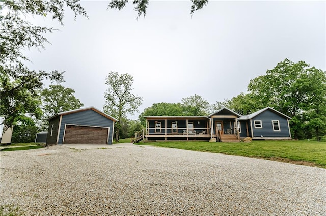 ranch-style home featuring an outdoor structure, a detached garage, and a front lawn
