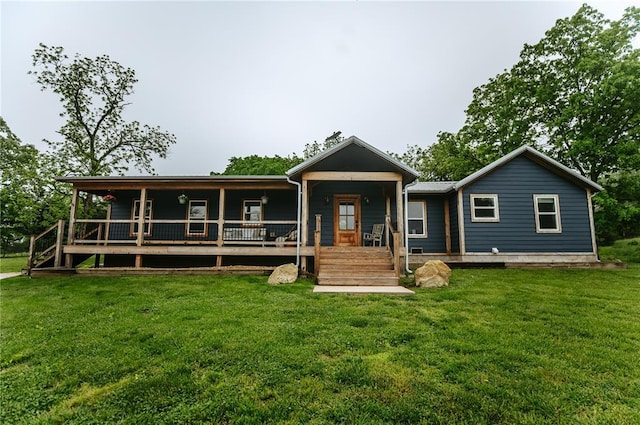 rear view of house featuring a porch and a lawn