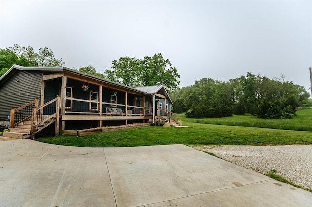 rear view of house featuring a porch and a yard
