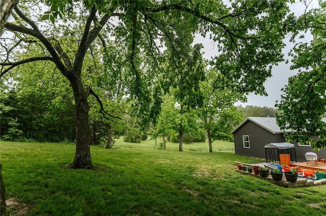 view of green lawn featuring a wooden deck