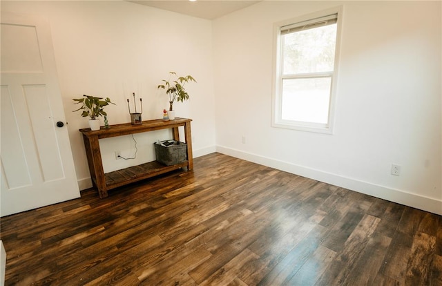 unfurnished room featuring dark wood-style floors and baseboards