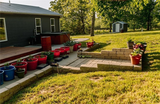 view of patio / terrace featuring a hot tub, a storage unit, a wooden deck, and an outbuilding