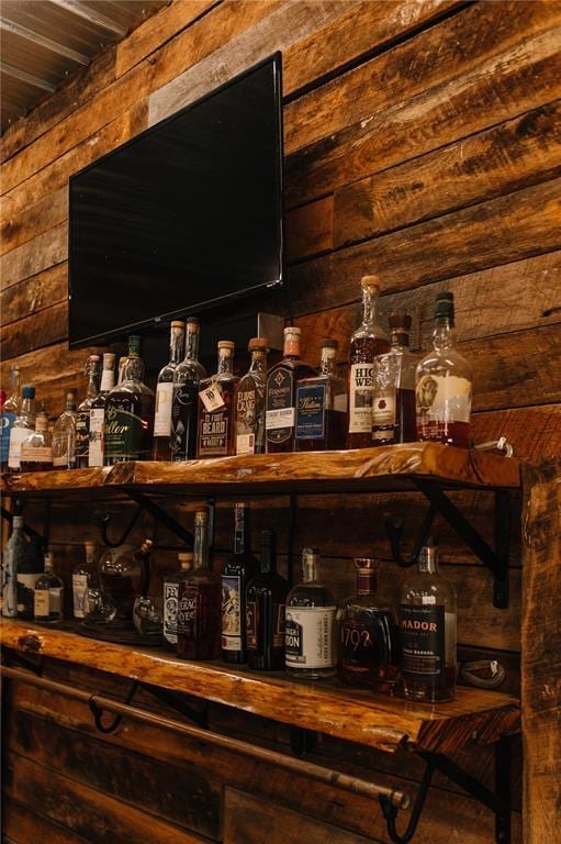 indoor dry bar featuring wood walls