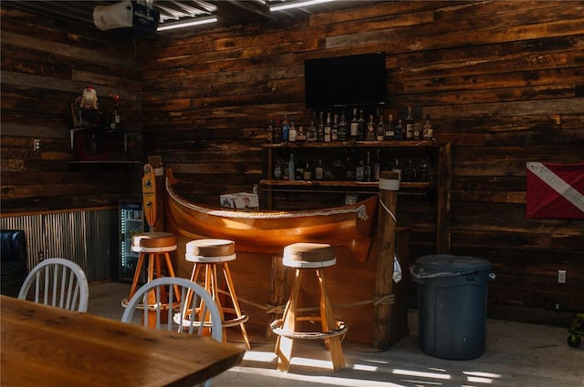 indoor dry bar featuring wood walls