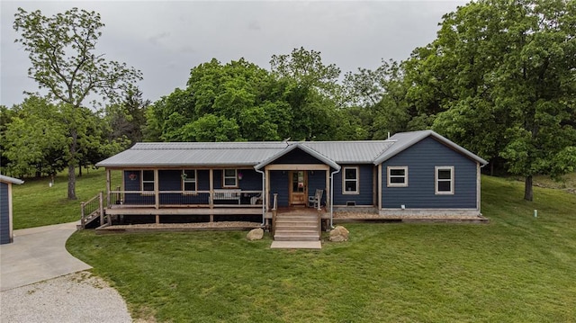view of front of property with a porch, a front lawn, and metal roof