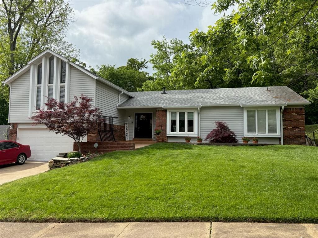503 Clayworth Dr, Ballwin, MO 63011 - tri-level home with a front lawn, brick siding, an attached garage, and driveway