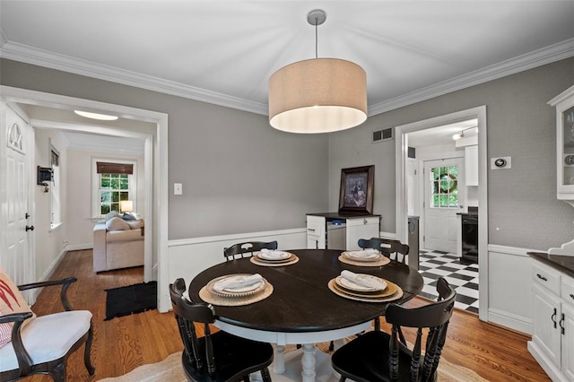 301 Dawson Ct, Webster Groves, MO 63119 - dining room featuring plenty of natural light, crown molding, light wood-style flooring, and wainscoting