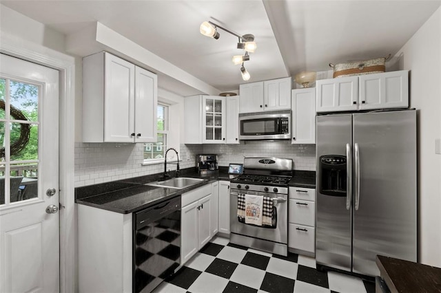 301 Dawson Ct, Webster Groves, MO 63119 - kitchen with appliances with stainless steel finishes, a sink, dark flooring, white cabinetry, and plenty of natural light