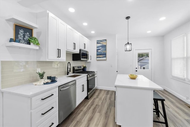 kitchen with stainless steel appliances, a sink, open shelves, a center island, and a breakfast bar
