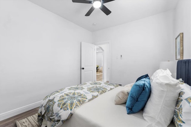 bedroom with wood finished floors, baseboards, and a ceiling fan