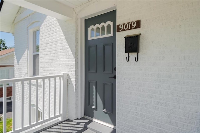 view of exterior entry featuring brick siding