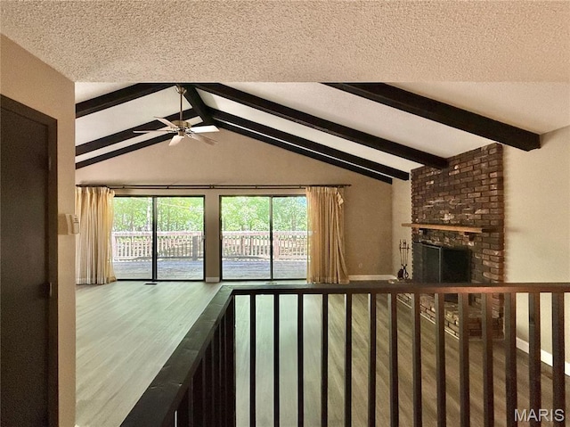 8305 Brouk Dr, Cedar Hill, MO 63016 - unfurnished living room with a textured ceiling, ceiling fan, wood finished floors, and a brick fireplace