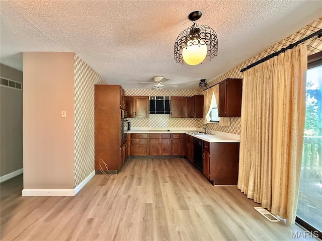 8305 Brouk Dr, Cedar Hill, MO 63016 - kitchen with black appliances, a sink, light wood-style flooring, light countertops, and a textured ceiling