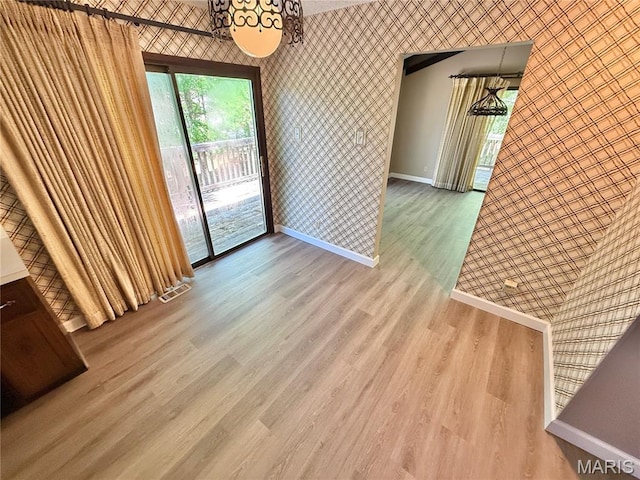 8305 Brouk Dr, Cedar Hill, MO 63016 - unfurnished dining area with wallpapered walls, baseboards, wood finished floors, and a chandelier