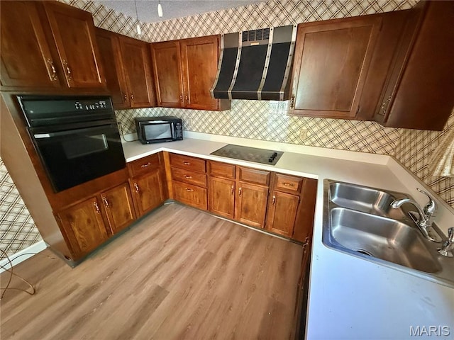 8305 Brouk Dr, Cedar Hill, MO 63016 - kitchen featuring extractor fan, black appliances, light wood-style flooring, and light countertops
