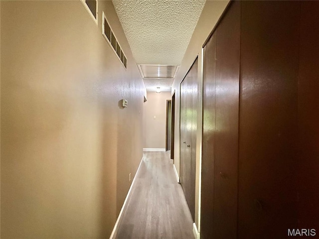 8305 Brouk Dr, Cedar Hill, MO 63016 - hallway with a textured ceiling, light wood-type flooring, and baseboards