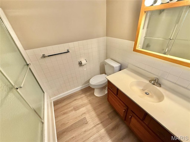 8305 Brouk Dr, Cedar Hill, MO 63016 - full bathroom with wood finished floors, tile walls, vanity, toilet, and a wainscoted wall