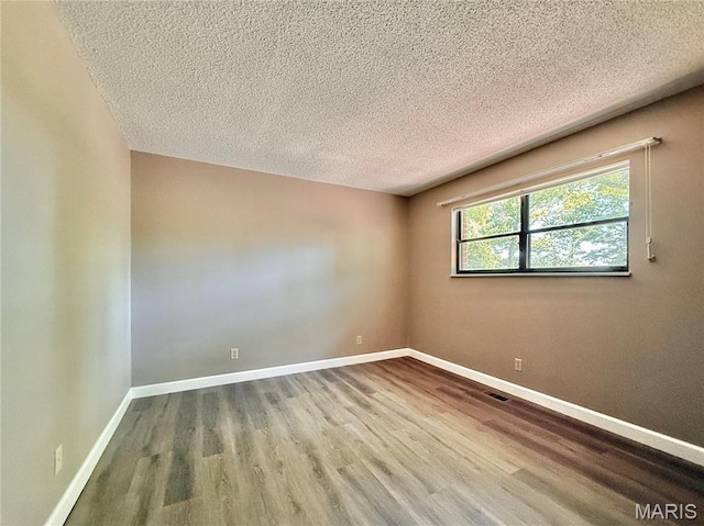 8305 Brouk Dr, Cedar Hill, MO 63016 - unfurnished room featuring a textured ceiling, wood finished floors, and baseboards