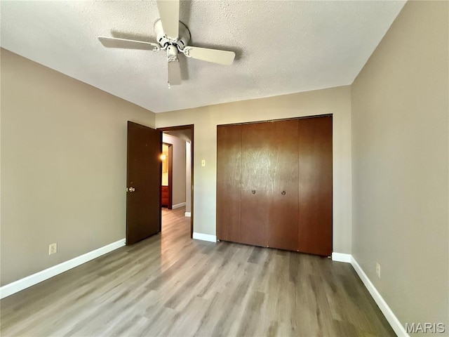 8305 Brouk Dr, Cedar Hill, MO 63016 - unfurnished bedroom featuring wood finished floors, baseboards, a closet, a textured ceiling, and a ceiling fan